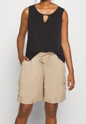 Czarna bezrękawnikowa bluzka z dekoltem w kształcie łezki, w zestawieniu z beżowymi szortami w stylu cargo z elastyczną talią i kieszeniami bocznymi.