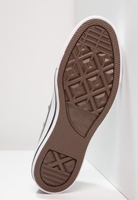 Braune Gummisohle mit strukturiertem geometrischem Muster, weißen Seitenakzenten und Markenlogo. Profil eines Sneaker-Designs, schräger Blick.