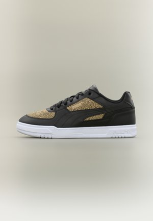 Madalad tossud mustast nahast, pruunikirjud kangaspaneelid, mustad paelad ja valge tallaosaga, millel Puma logo küljel ja kontsal.