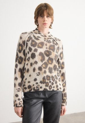 Luipaardprint trui in beige en bruin tinten, geribbelde boorden en zoom, ronde hals met een ritsdetail. Gemaakt met zwarte broek.