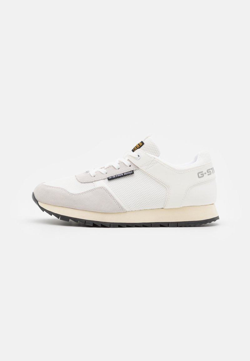 Baskets basses blanches et beiges avec des panneaux en mesh et en daim, étiquette logo G-Star Raw noire, et semelle en caoutchouc noire avec une adhérence texturée.