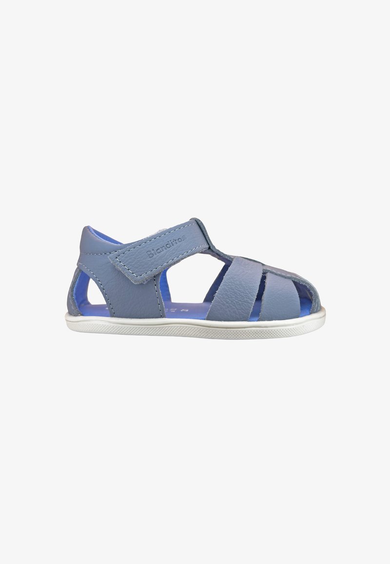 Sandale enfant en cuir bleu avec bout et talon ouverts, bride velcro réglable et semelle en caoutchouc blanche.