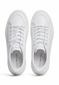 Sneaker bianche con tomaia in pelle liscia, punta rotonda, chiusura con lacci piatti e suola in gomma. Presentano un marchio sottile sulla soletta.