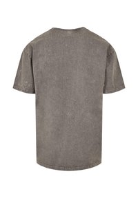Pilkas trumpas rankovėmis T-shirt, pagamintas iš minkštos medvilnės, su tekstūruotu paviršiumi ir šiek tiek nublukusia išvaizda. Klasikinio apvalaus kaklo dizainas.