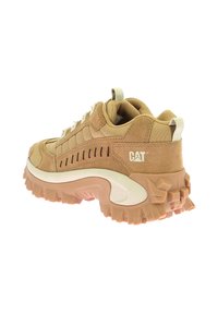 Sneaker color sabbia con suola spessa, realizzate in un mix di materiali scamosciati e tessili, con un motivo testurizzato e un sottile logo sul lato.