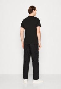 Calvin Klein Jeans STACKED EUPHORIC LOGO TEE - Camiseta estampada - black