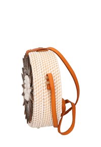 Borsa tonda intrecciata in paglia naturale con un design floreale bianco e marrone, completata da una tracolla in pelle color cuoio.