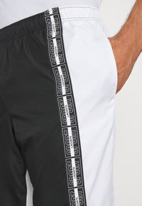Lacoste Sport TENNIS PANT - Pantalones deportivos - noir/blanc