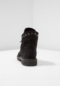 Botas de tobillo de ante negro con punta redonda, ojales de metal decorativos a lo largo del puño y detalles texturizados en el tacón.