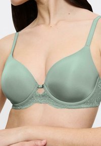 Sostén acolchado de color verde musgo con detalles de encaje, textura suave, tirantes ajustables y un detalle en forma de llave en el centro.