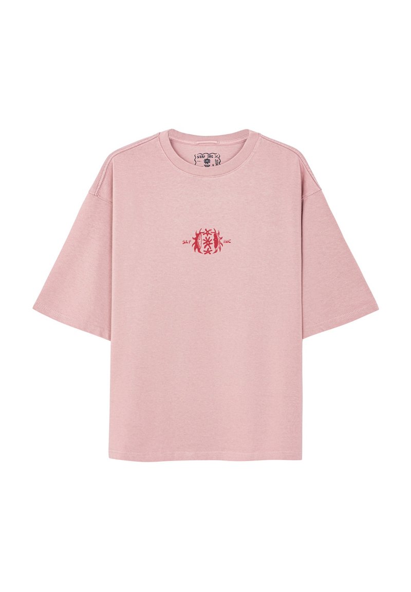 Różowa bawełniana koszulka z luźnym krojem, krótkimi rękawami, okrągłym dekoltem i małym czerwonym wzorem na piersi.