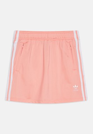 Gonna sportiva color pesca con vita elastica, strisce laterali bianche e tasche con zip. Presenta il logo Adidas in bianco in basso a sinistra.