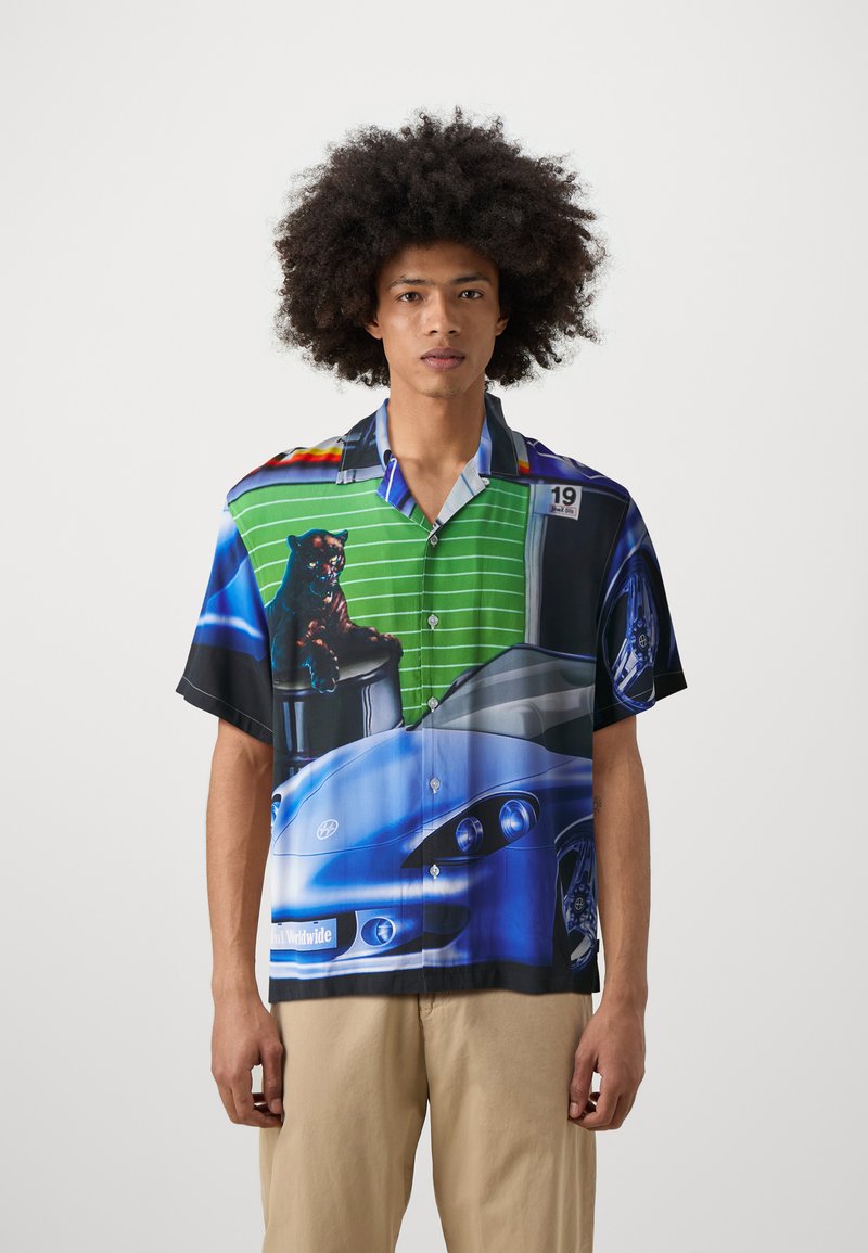Korte mouw knoopshirt met een levendig grafisch patroon op een groene gestreepte achtergrond, met afbeeldingen van auto's en een zwart pantermotief.