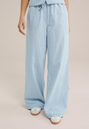 Pantalon large bleu clair à rayures blanches verticales, réalisé dans un tissu doux ; dispose d'une taille élastique et de poches latérales.