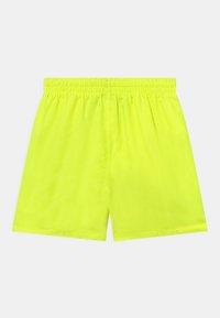 Pantalones cortos de color amarillo neón con cinturilla elástica, textura suave y un corte holgado. Sin bolsillos ni elementos de diseño adicionales visibles.