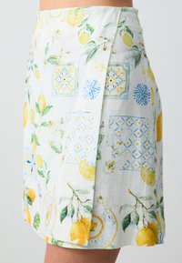Gonna con motivo floreale che presenta design a piastrelle in limone e blu. Realizzata in tessuto leggero con una parte anteriore plissettata e un orlo sottile.