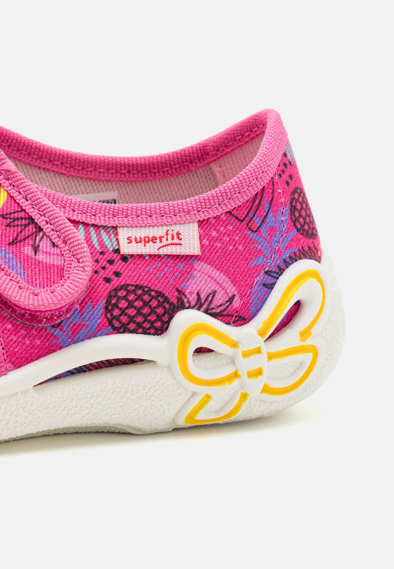 Rosa Schuhe aus strukturiertem Stoff mit Ananas-Mustern, weißen Gummisohlen und einem gelben, schleifenförmigen Akzent an der Seite.