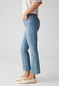 Hellblaue Denim-Jeans mit einer taillierten Taille und leicht ausgestelltem Knöchel. Weiche Textur mit minimaler Ausbleichung und klassischem Fünf-Taschen-Design.