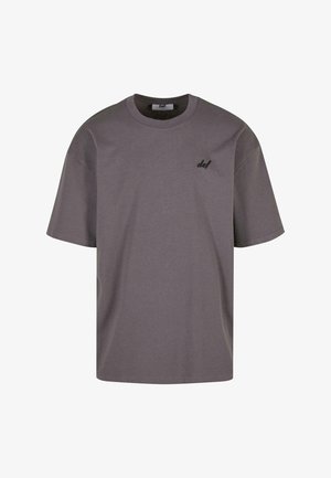 Tricou din bumbac gri, cu mâneci scurte, croială lejeră și un mic logo negru pe partea stângă a pieptului. Decolteu rotund, textură fină, design simplu.