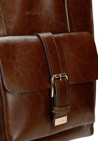 Borsa a tracolla in pelle marrone con texture liscia, dotata di una patta frontale e una fibbia metallica. Logo del marchio impresso sulla pelle.