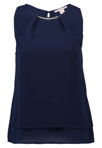 Marinblus utan ärmar tillverkad av glatt tyg, med en detalj i form av ett nyckelhål i ryggen och en subtil pärlaccent längs halsringningen.