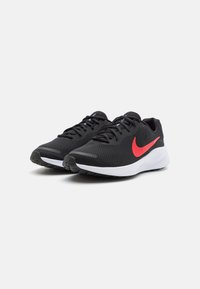 Svarta träningsskor med en texturerad mesh-övre del, röd Nike-logotyp, vadderad vit mellansula och svart gummiyttersula med greppmönster.