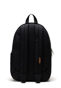 Svart ryggsäck med rundad form, tillverkad av tygmaterial, vertikala sömmar, läderdetaljer och två axelremmar. Fick med dragkedja på sidan.