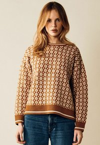 Stickad tröja i brunt och cream med ett diamantmönster, ribbad rundhalsad krage och muddar, kompletterad med en ribbad nederkant.