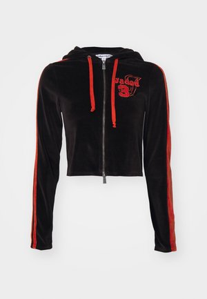 Juodas veliūro trumpas džemperis su raudonu užtrauktuku, raišteliais ir šoninėmis juostelėmis. Pasižymi siuvinėtu logotipu priekyje. Lygi tekstūra.