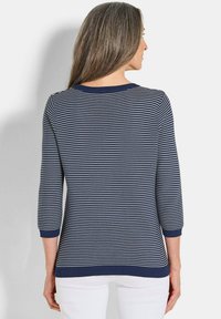 Maglione a righe navy e bianche in maglia con maniche a tre quarti e scollatura rotonda, caratterizzato da un bordo a coste ai polsi e all'orlo.