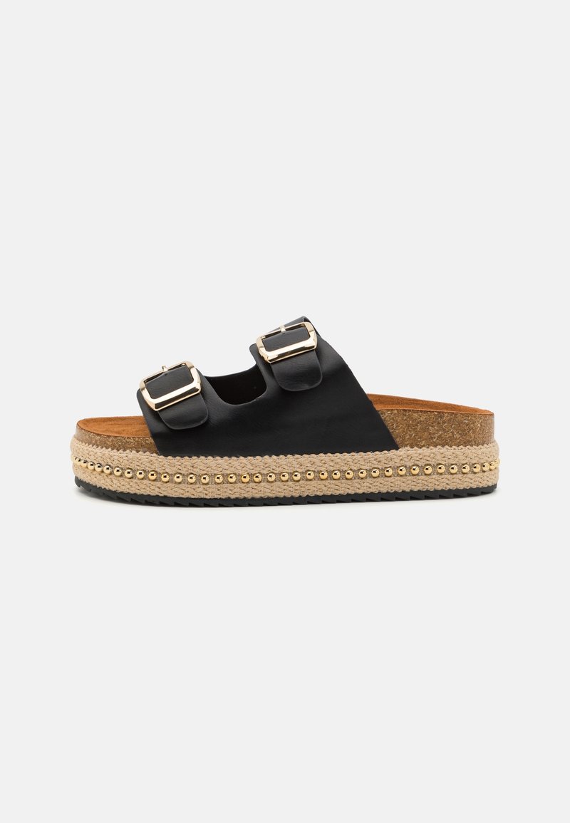 Sandales noires à glissière avec deux boucles, une semelle en jute tissée et une semelle intermédiaire texturée accentuée de petites perles dorées. Design plat pour plus de confort.
