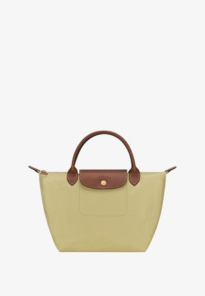 Canvas tote bag in light green with brown leather accents. Features a rounded handle, flap with a snap closure, and minimalistic design.