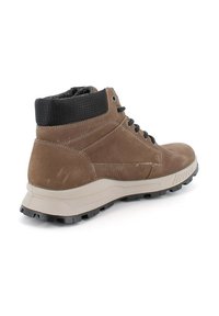 Botas de tobillo de cuero marrón con un cuello negro texturizado y una suela de goma gris. Cuentan con un diseño con cordones y patrones texturizados en el cuello.