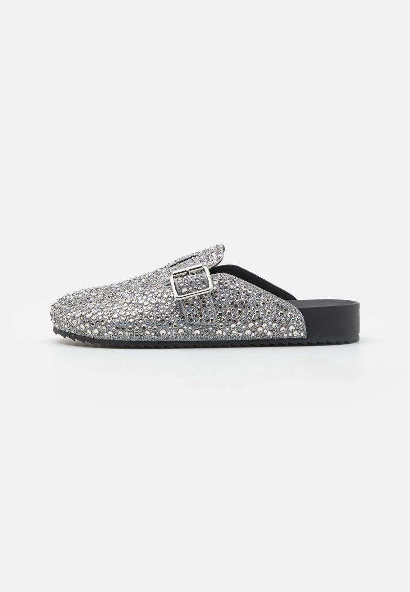 Silver slip-on mules covered in shiny rhinestones, featuring a buckle accent, a rounded toe, and a durable black sole.