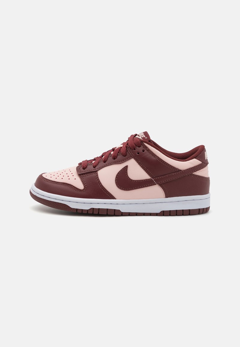 Nike Dunk Low tenisice imaju gornji dio od tamnocrvene kože s ružičastim detaljima, perforiranim prednjim dijelom i bijelom srednjom podlogom s gumiranim potplatom.