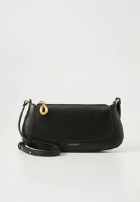 Black leather shoulder bag with gold zipper pull and small Calvin Klein logo, featuring an adjustable strap with gold-tone hardware.