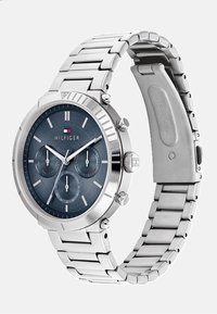 Montre chronographe en acier inoxydable argenté avec un cadran texturé bleu, trois sous-cadrans et un bracelet style bande avec fermoir.