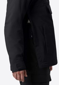 Černá nepromokavá bunda s hladkým povrchem, která má boční kapsu a nastavitelné manžety. Design je štíhlý a funkční.