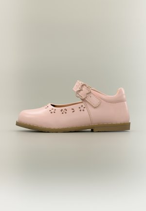 Roze Mary Jane-schoen met bloemenuitstansingen, gespband en bruine platte zool, zijaanzicht op neutrale achtergrond.
