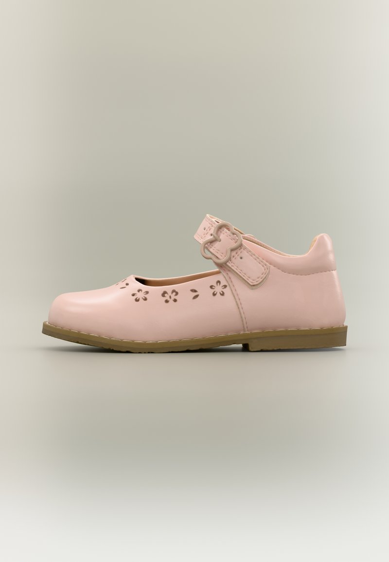 Chaussure Mary Jane rose avec découpes florales, bride à boucle et semelle plate marron, vue de profil sur fond neutre.