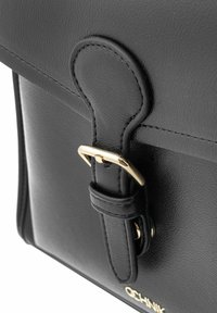 Zbliżenie czarnej skórzanej torby z widoczną złotą klamrą i paskiem, podkreślające jej wypolerowaną teksturę i elegancki design.