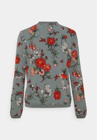 Szary sweter z długimi rękawami w kwiatowy wzór z czerwonymi, różowymi i białymi kwiatami, zielonymi liśćmi oraz małymi czerwonymi ptakami.