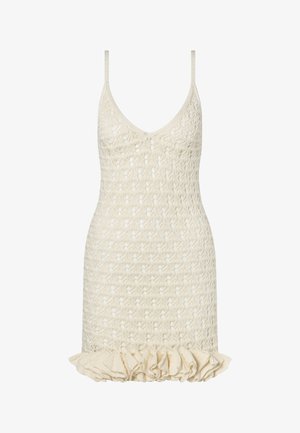 Κρεμ αμάνικο πλεκτό φόρεμα με λεπτές τιράντες, λαιμόκοψη σε σχήμα V και βολάν στο τελείωμα.
