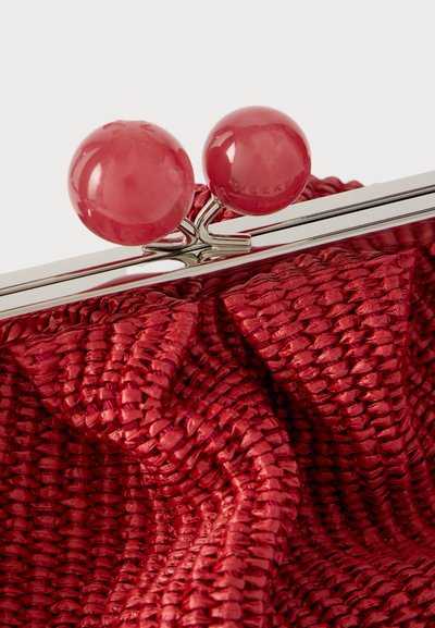 Κόκκινο υφαντό ύφασμα σε θήκη με γυαλιστερό ασημένιο κούμπωμα και δύο μεγάλα γυαλιστερά κόκκινα σφαιρικά κουμπιά που ασφαλίζουν το κλείσιμο.