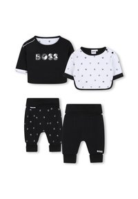 Due set di abbigliamento per bambini: maglietta nera a maniche corte con logo 'BOSS', maglietta bianca a pois e pantaloni neri con motivo a pois argentati.