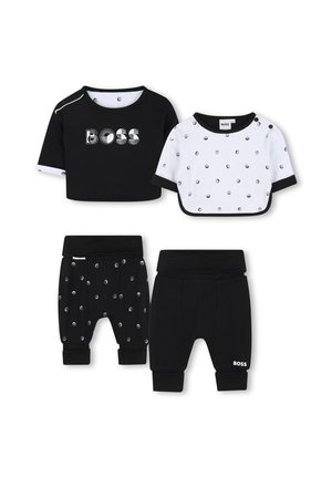 Deux ensembles de vêtements pour enfants : un haut noir à manches courtes avec le logo 'BOSS', un haut blanc à pois et un pantalon noir avec un motif de pois argentés.