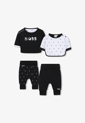 Due set di abbigliamento per bambini: maglietta nera a maniche corte con logo 'BOSS', maglietta bianca a pois e pantaloni neri con motivo a pois argentati.