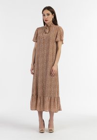 Rochie maxi floral maro cu mâneci scurte, tiv volănaș și fundă la gât. Fabricată dintr-un material ușor, are un luciu subtil și un model delicat.