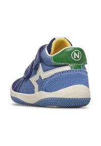 Sneaker blu per bambini con una fascia in velcro, upper in suede e tessuto, accento a forma di stella bianca, linguetta verde sul tallone e suola in gomma testurizzata.