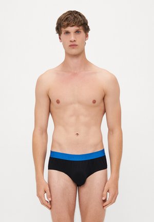 Schwarze Unterhosen mit einem blauen Gummibund, der das "HUGO"-Branding trägt. Der Stoff wirkt weich, und das Design ist klassisch und körpernah.